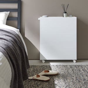 Hvit oppbevaringsvogn med tre hyller brukt som sidebord ved skrivebord.