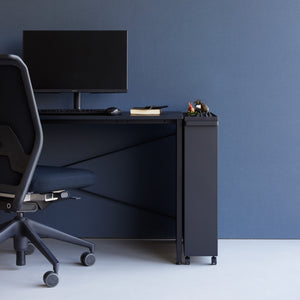 Smal sort hyllevogn med bøker og dekor i stue.