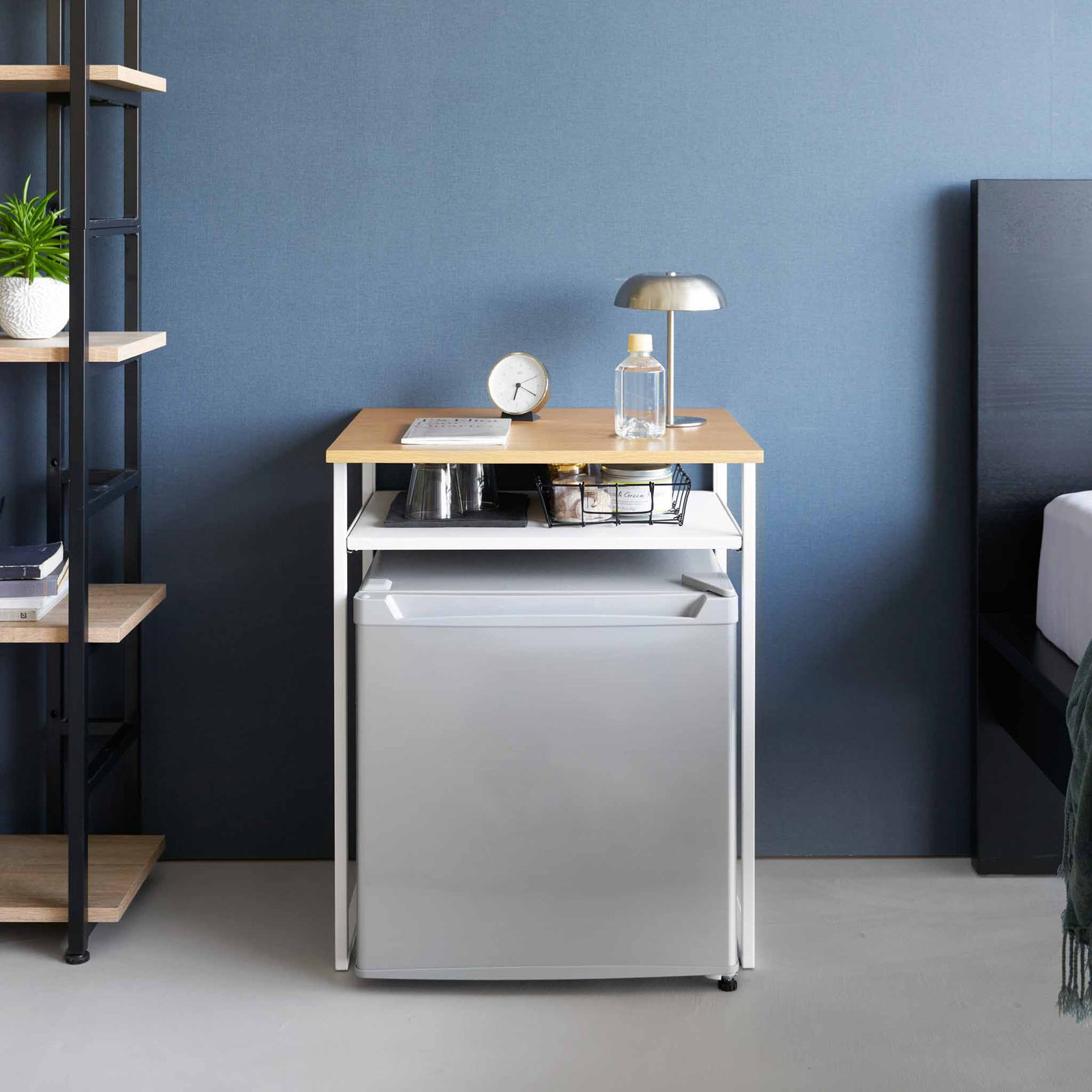 Sidebord med treplate plassert over minikjøleskap i soverom