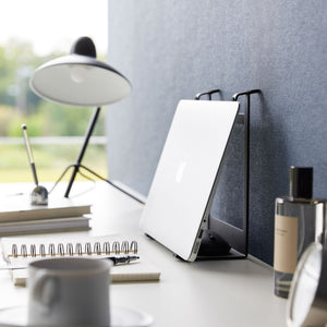 Ergonomisk stativ i sort metall brukt til både laptop og nettbrett.