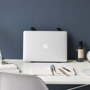 Sammenleggbart sort stativ for laptop på hjemmekontor.