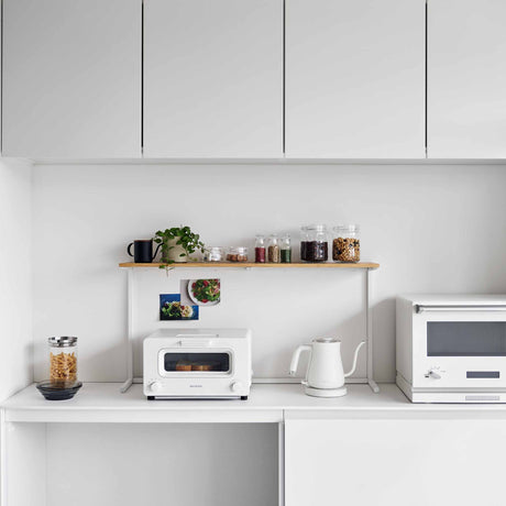 Kjøkkenhylle med krydderglass og planter på kjøkkenbenk