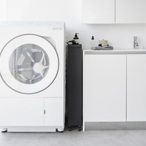 Detaljbilde av sorte hjul på oppbevaringsvogn med fire hyller.