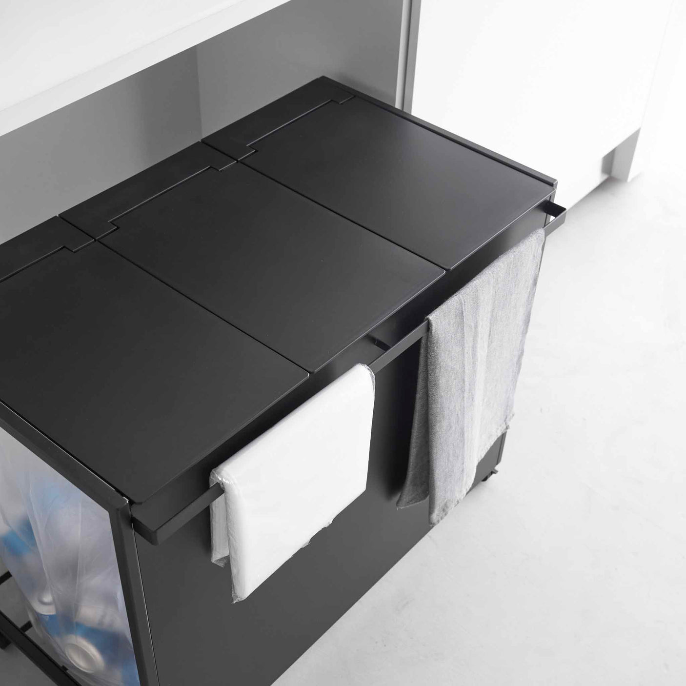 Lokk med håndtak på kildesorteringsstativ som skjuler avfallsposer