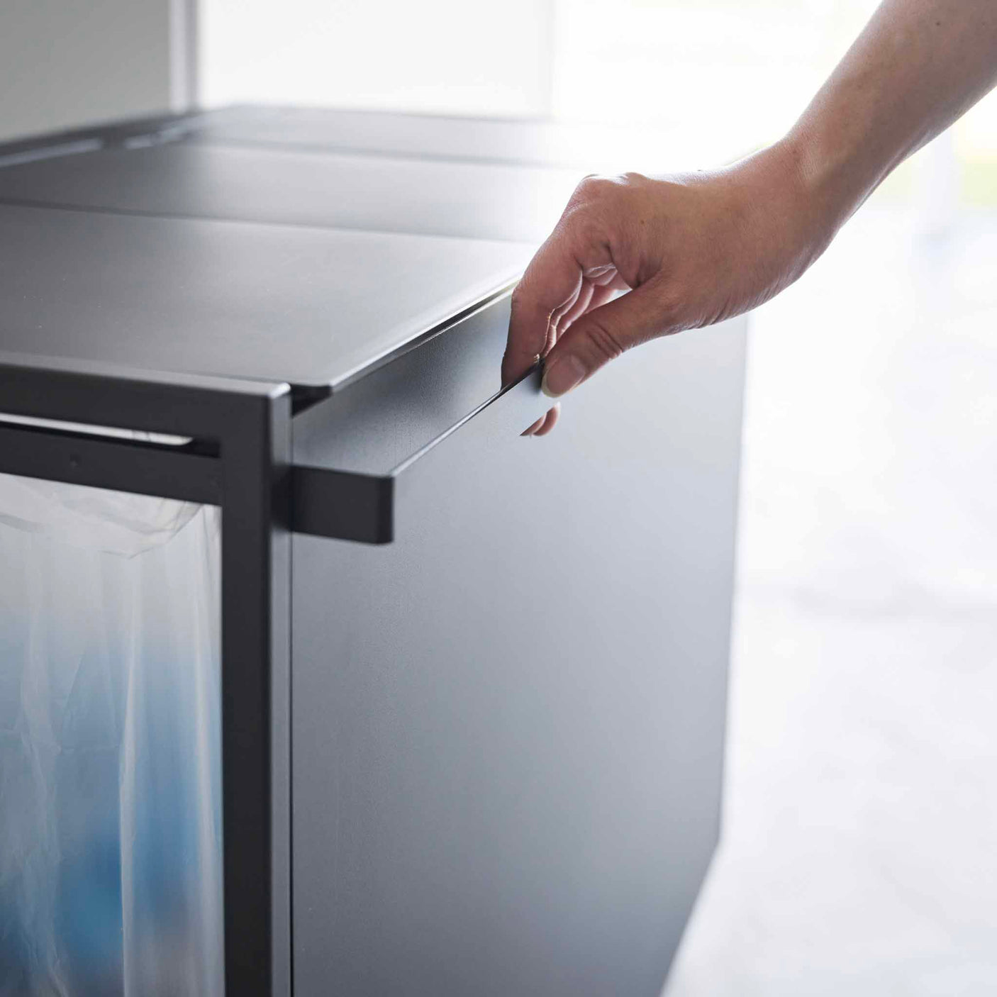 Detaljbilde av håndtak på avfallssorteringsstativ i stål