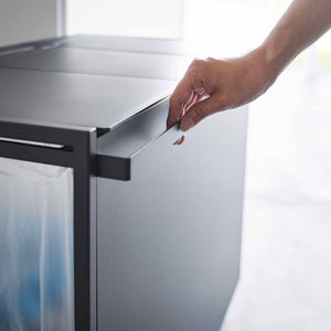 Detaljbilde av håndtak på avfallssorteringsstativ i stål