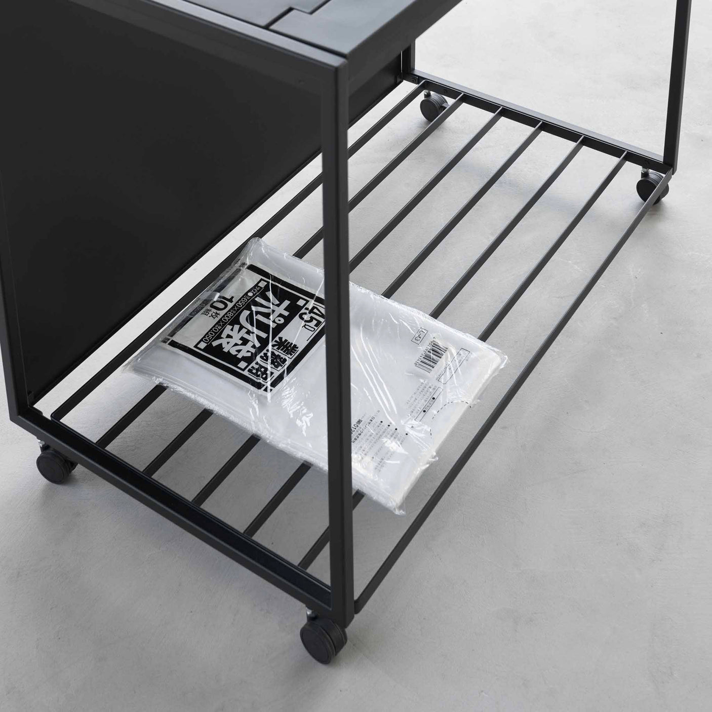 Oppbevaringshylle nederst på kildesorteringsstativ for ekstra poser eller tilbehør