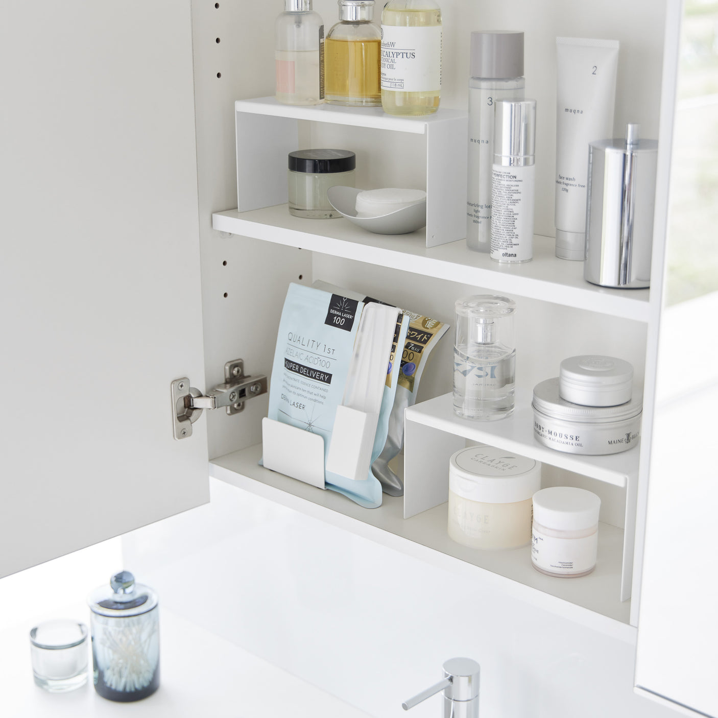 Flere stabelbare kjøkkenhyller organisert på benk med krydder.