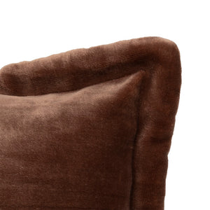 Brun flanellpute i sofa blant lyse puter