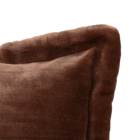 Brun flanellpute i sofa blant lyse puter