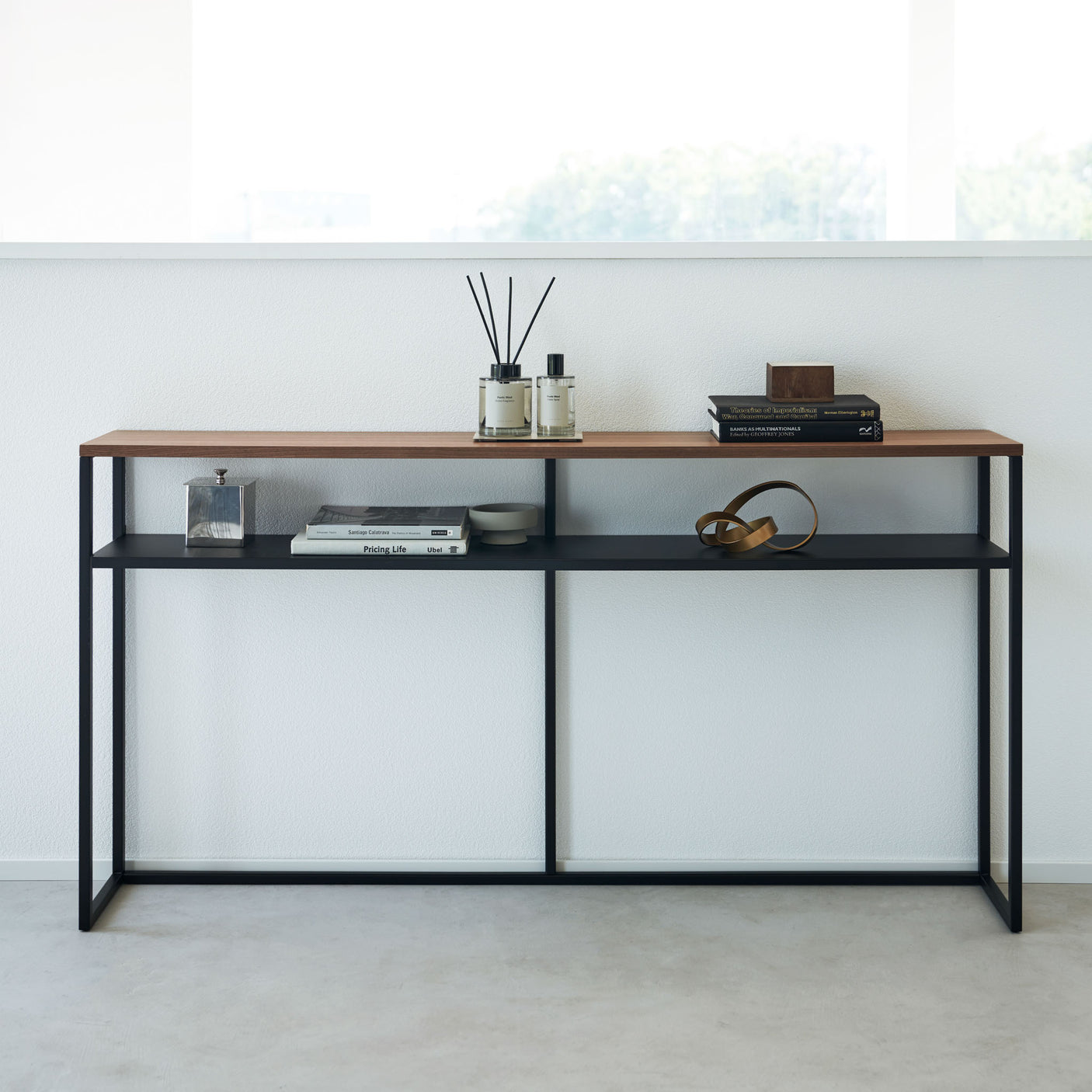 Konsollbord med sort metallramme og treoverflate ved vindu.