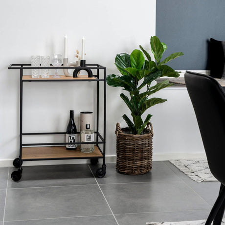 Serveringsvogn i sort og eik plassert i moderne stue
