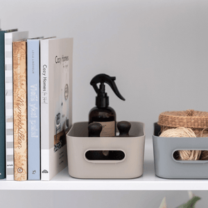 Beige og grå SmartStore Comfort oppbevaringskurver på stuehylle med romspray, bøker og pynt