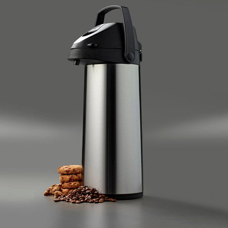 Pumpekanne i mat stål i et stemningsbillede med kaffebønner og kiks