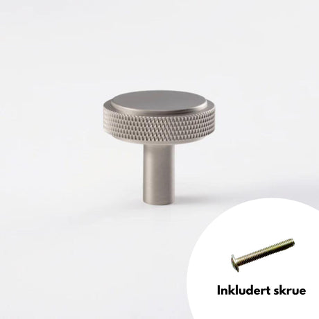 Nærbilde av en børstet nikkel knott med rillet tekstur, inkludert skrue, vist mot hvit bakgrunn.