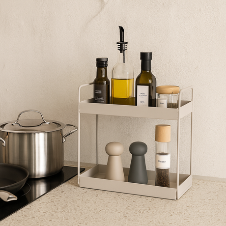 Beige metallhylle på kjøkkenbenk fylt med oljeflasker og krydder ved siden av en kjele på koketoppen.