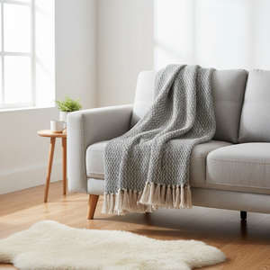 Kvadratisk bilde av pledd plassert i kurv ved moderne interiør