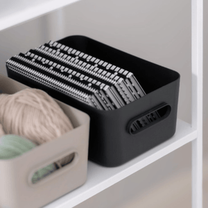 Kokegrå SmartStore Comfort opbevaringskurv med strikkepinde ved siden af en beige kurv med garn