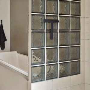 Ume dusjskrape i sort montert på vegg ved dusj