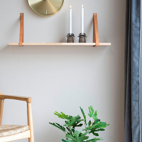 Forno vegghylle over stol med plante og dekor i nordisk stue