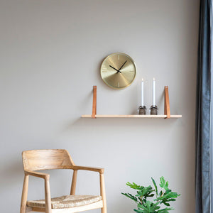 Brune skinnstropper på vegghylle i naturtre