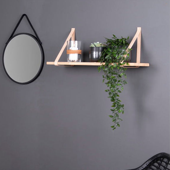 Detalj av brune skinnstropper og naturlig trestruktur