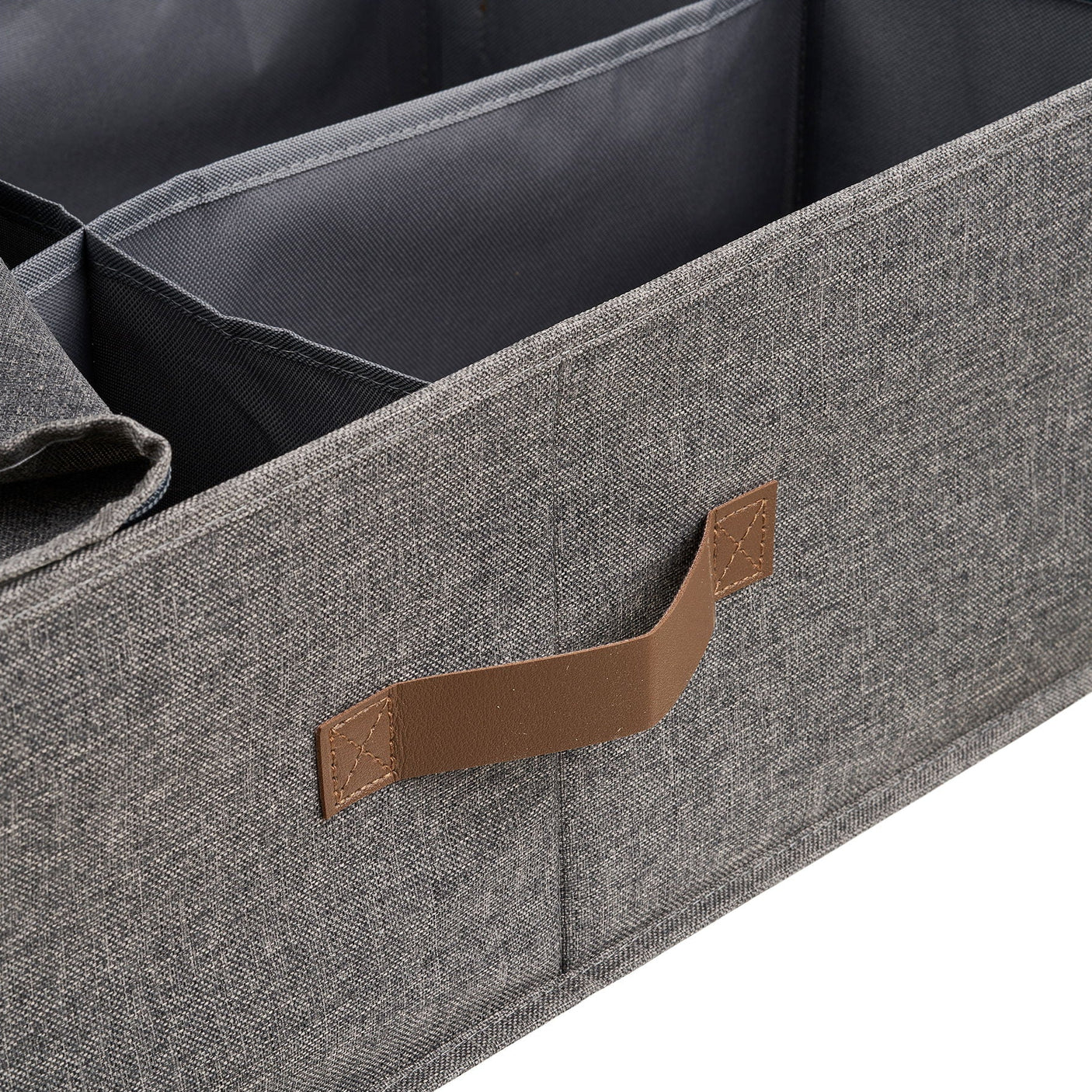 Nærbilde av brunt PU-håndtak på mørk grå tekstilkurv