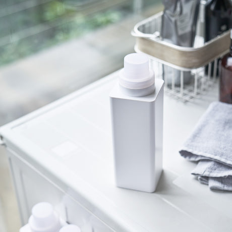 Hvit magnetisk flaske for oppbevaring av såpe eller vaskemiddel.