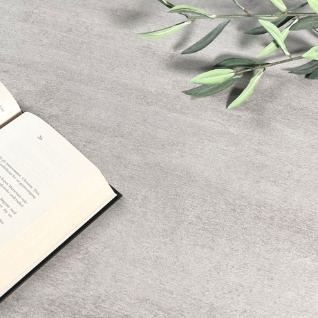 Grå mikrosement kontaktplast med bok og grønn plante, ideell til dekorative flater.