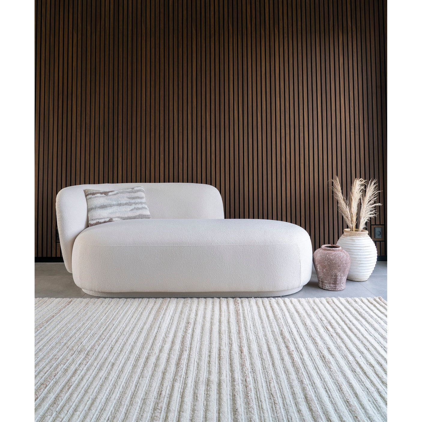 Mykonos Daybed naturfarget plassert i moderne stue med trepanel og dekor.