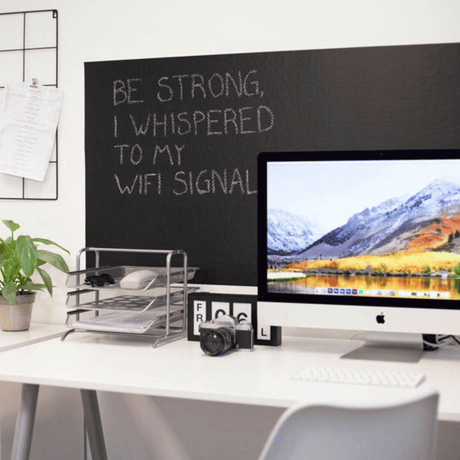 Tavlefolie på hjemmekontor bak skjerm, svart krittavle med motiverende tekst og notater
