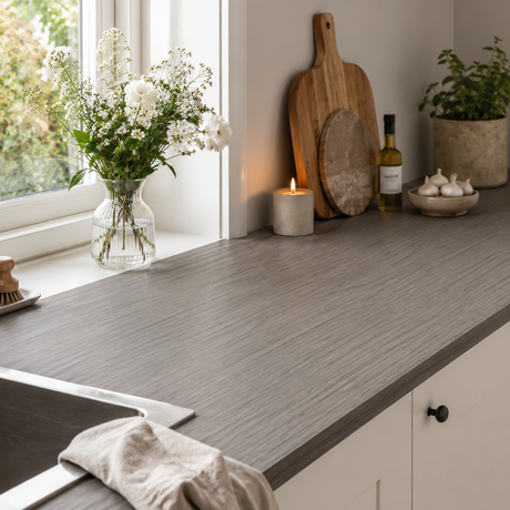 Kjøkkenbenk foliert med Calm Greige kontaktplast i varm gråbeige trefinish ved vindu med naturlig dagslys