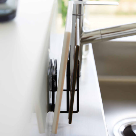 Selvklebende sort oppbevaring til skjærebrett som frigjør benkeplass