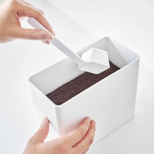 Lufttett kaffeboks med praktisk skje og plassbesparende design.