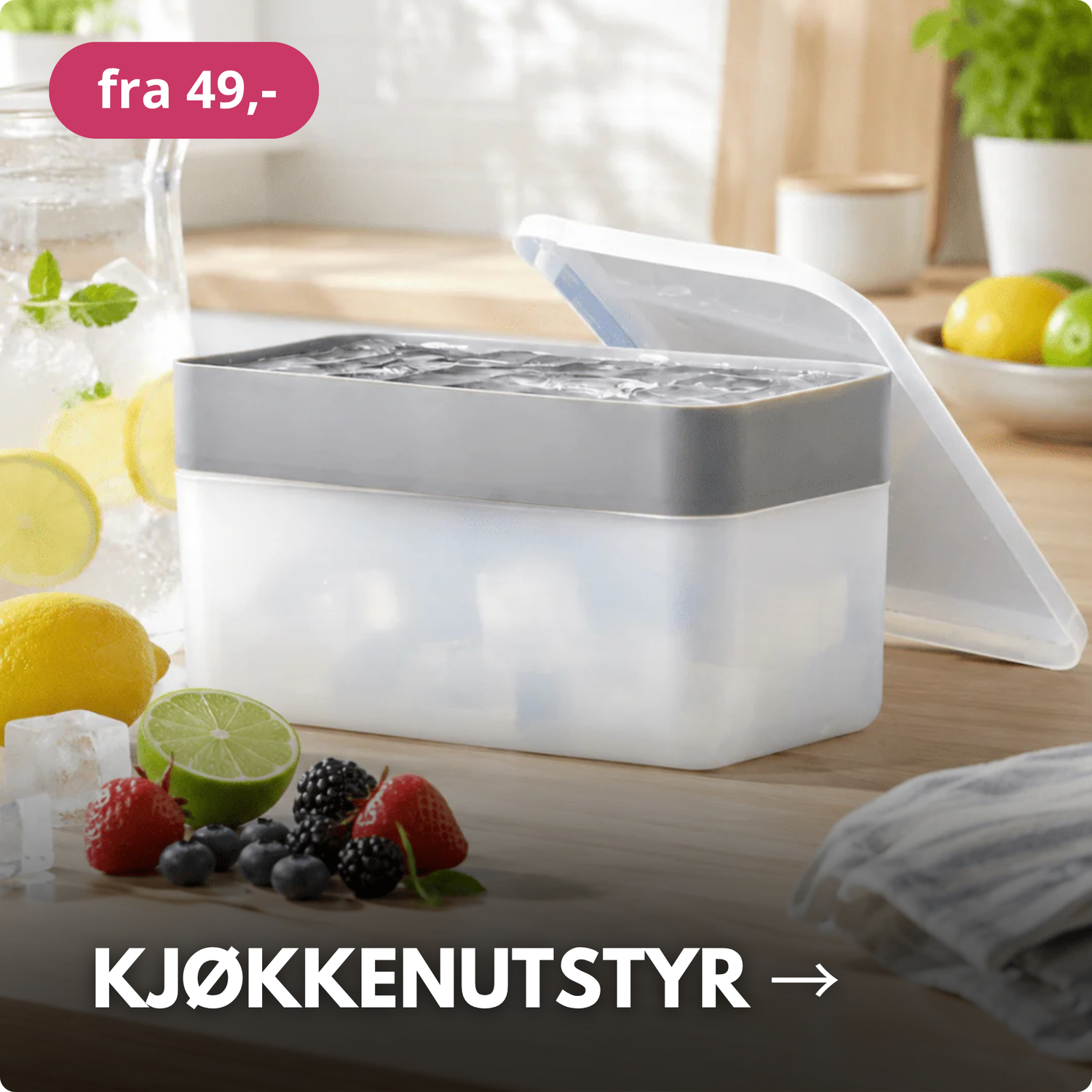 Isbitboks med lokk på kjøkkenbenk omgitt av frukt og ingredienser til kalde drikker.