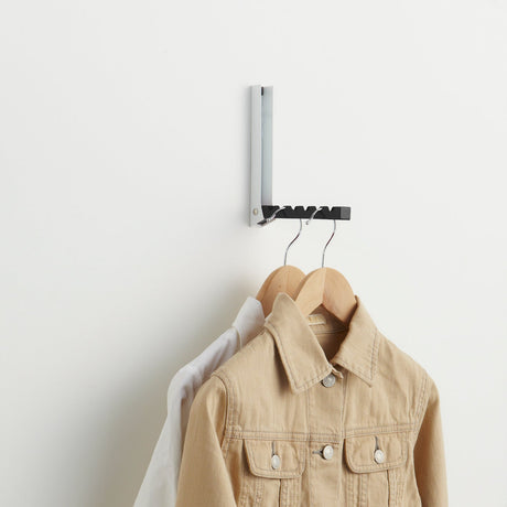 Sort metallstativ for oppbevaring av kleshengere.