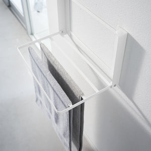 Luftig bad med hvit sammenleggbar oppbevaringshylle.