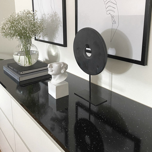 Sort kontaktplast med granittdesign montert på benkeplate i moderne kjøkken.