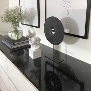 Sort kontaktplast med granittdesign montert på benkeplate i moderne kjøkken.
