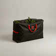 Svart oppbevaringsbag for juletre i solid stoff med røde detaljer, fotografert i naturlig kveldslys.