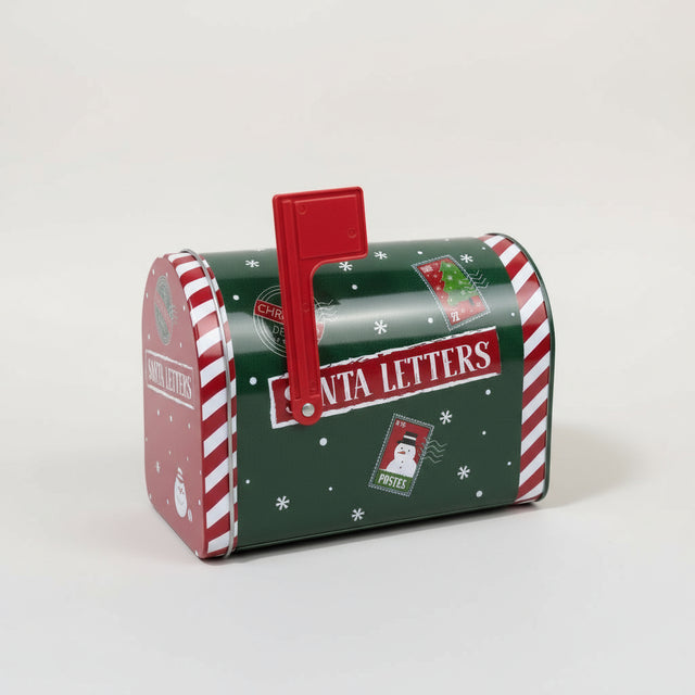 Grønn metallpostkasse med julemotiv brukt som dekor foran juletre