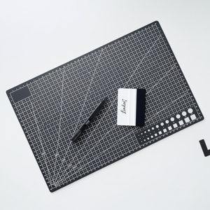 Skjærematte A3 med rutenett foliesletter og tapetkniv brukt til å kutte og glatte kontaktplast.

