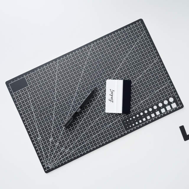 Skjærematte A3 med rutenett foliesletter og tapetkniv brukt til å kutte og glatte kontaktplast.

