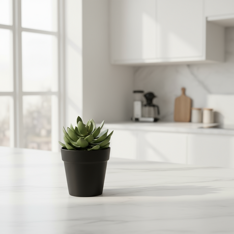 Kunstig grønn plante med tykke blader plassert på bord