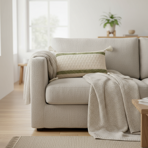 Dekorativ pute med dusker i hjørnene