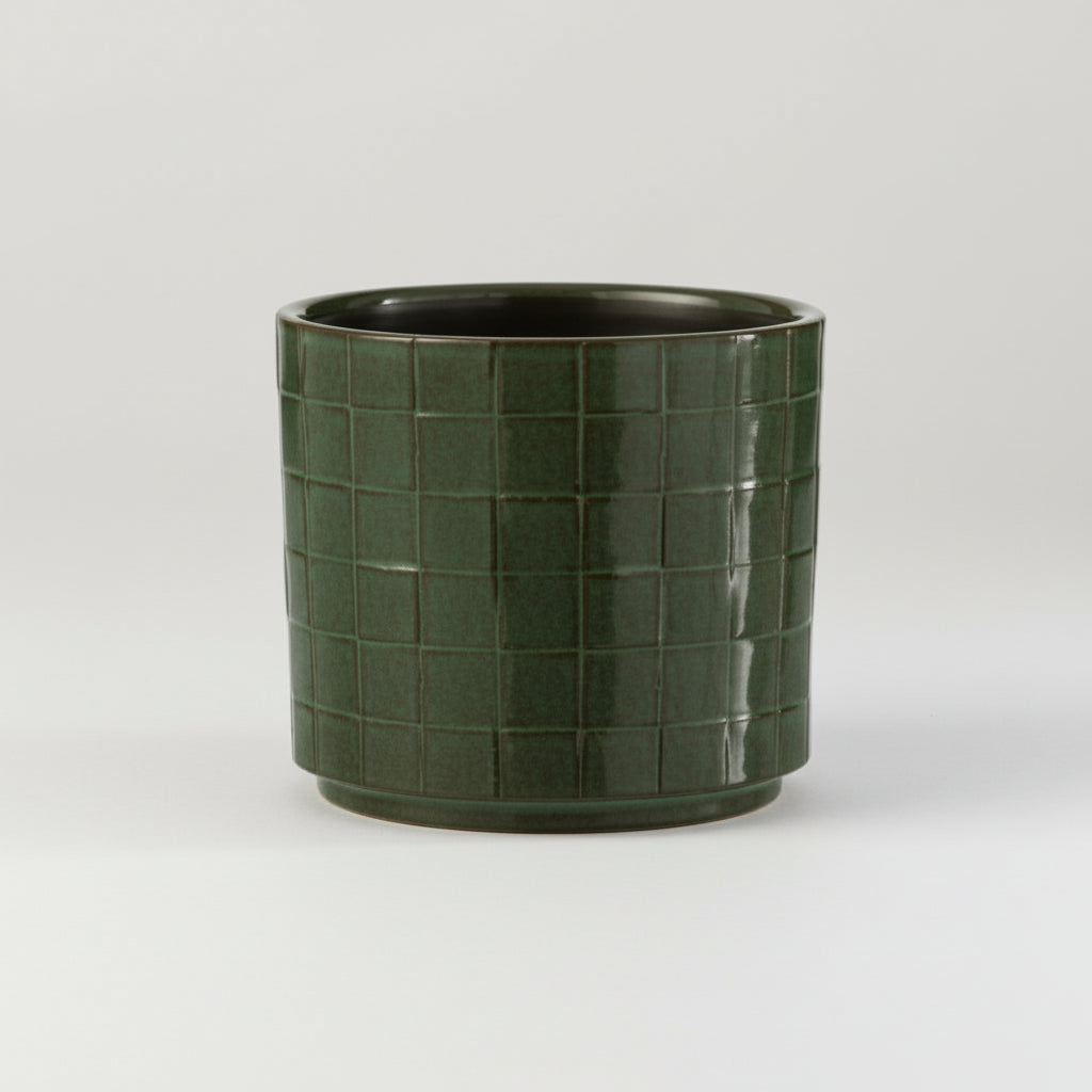 Firkantet grønn blomsterpotte i keramikk på hylle med planter, skandinavisk interiør