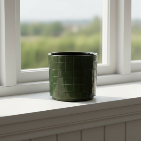 Detaljbilde av firkantet blomsterpotte i grønn keramikk med glatt finish