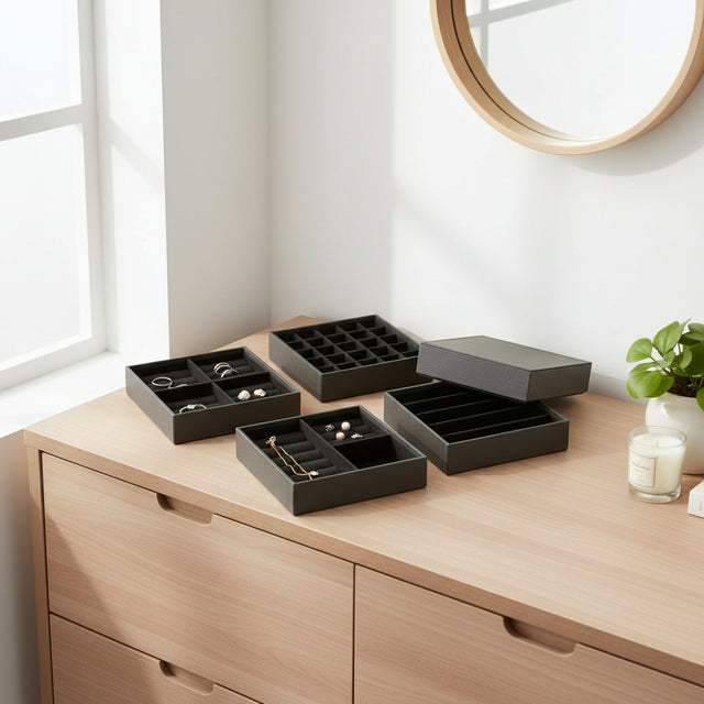 Svart smykkeboks i kunstskinn på kommode, elegant oppbevaring av smykker