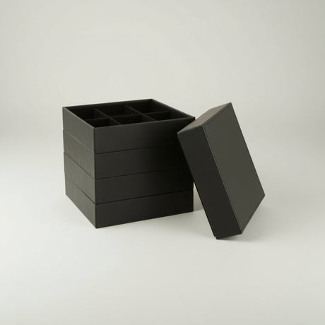 Detaljbilde av smykkeboks med 4 rom i svart kunstskinn, organisering av smykker