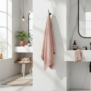 Rosa bomullshåndkle brettet på hvit bakgrunn